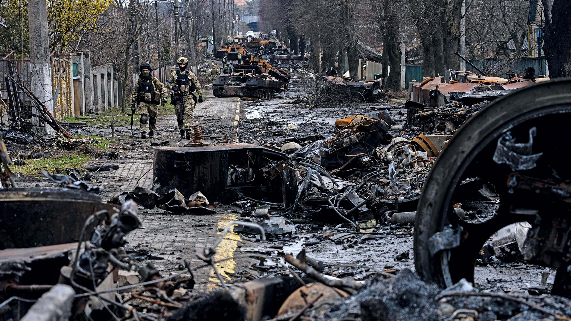 Zwei ukrainische Soldaten laufen Anfang April durch das weitgehend zerstörte Butscha nahe Kiew nach Abzug der russischen Truppen.
