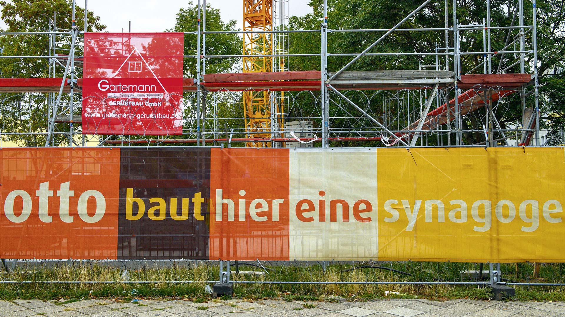 „Otto baut hier eine Synagoge“ steht auf einem Plakat am Bauzaun der Baustelle der Synagoge Magdeburg, September 2022.
