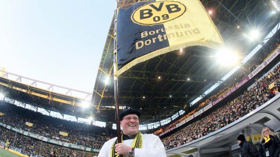 Die Standarte des BVB wird von einem Pfarrer ins Stadion getragen.