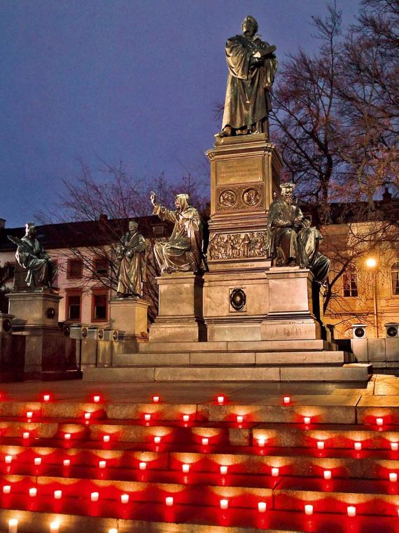 Lichter bei einer Mahnwache für die Corona-Opfer am Wormser Lutherdenkmal, zu der die beiden großen Kirchen am 17. Januar aufgerufen hatten