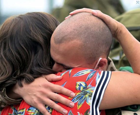 Ein Soldat umarmt eine Frau zum Abschied oder zur Begrüßung