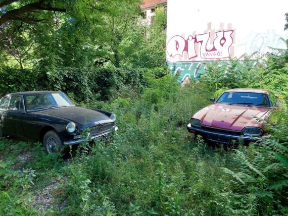 Zwei alte Sportwagen in einem verwilderten Hinterhof in Berlin