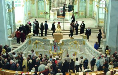 „Wandelabendmahl“ in der Dresdner Frauenkirche: Die Teilnehmer empfangen die Oblate und gehen weiter, um aus dem Kelche zu trinken. Foto: dpa/ Matthias Rietschel