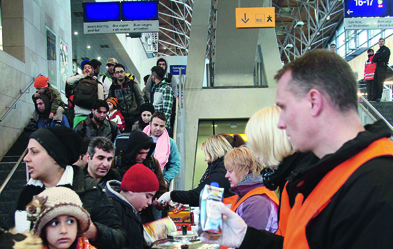 Foto: epd/ Harald Koch Ankunft von Flüchtlingen am Messebahnhof Laatzen bei Hannover. Ehrenamtliche schenken Tee aus.