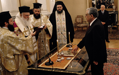 Ministerpräsident Lucas Papademos legt seinen Amtseid vor dem Erzbischof von Athen ab. Foto: dpa/Sophia Petrova
