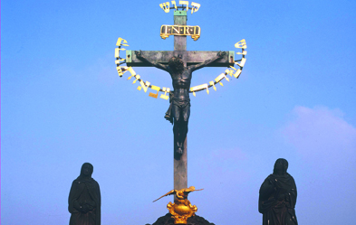 Auf dem Kruzifix der Prager Karlsbrücke steht seit 1669 auf Hebräisch das dreifache „Heilig“, das nach jüdischem Verständnis allein Gott zukommt. Ein Jude, der das Kreuz verhöhnt haben soll, musste die Inschrift bezahlen. Foto: dpa