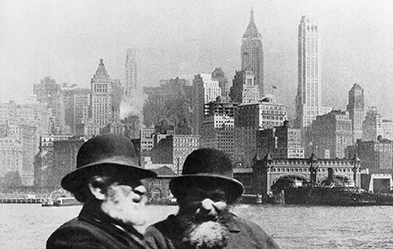 Jüdische Einwanderer um 1910 vor der Skyline von New York. Foto: dpa/ Archiv Gerstenberg