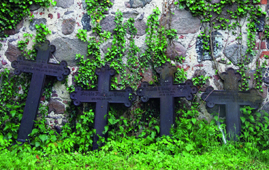 Alte Grabkreuze an der Kirchenmauer in Zahren, Mecklenburg-Vorpommern. Foto: epd/ Rainer Oettel