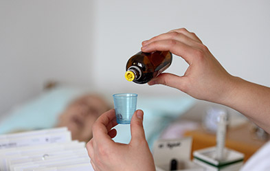 Eine Pflegerin dosiert Schmerzmittel im Pflegeheim „Lazarus Haus Berlin“ der Hoffnungstaler Stiftung Lobetal. Foto: dpa/ Juergen Blume